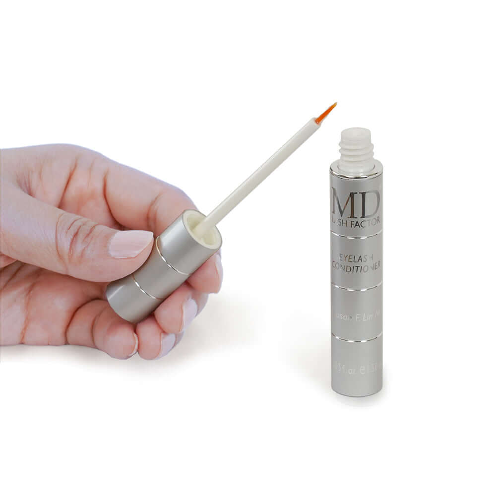 Hand holding MD Lash Factor Eyelash Conditioner precision brush showing clear serum consistency and applicator size – MD Lash growth serum