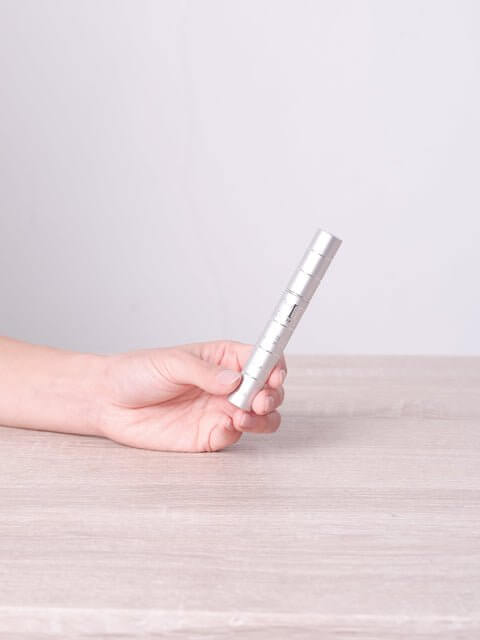 Hand holding MD Lash Factor 3-Month lash serum and conditioner bottle for visibly fuller-looking lashes